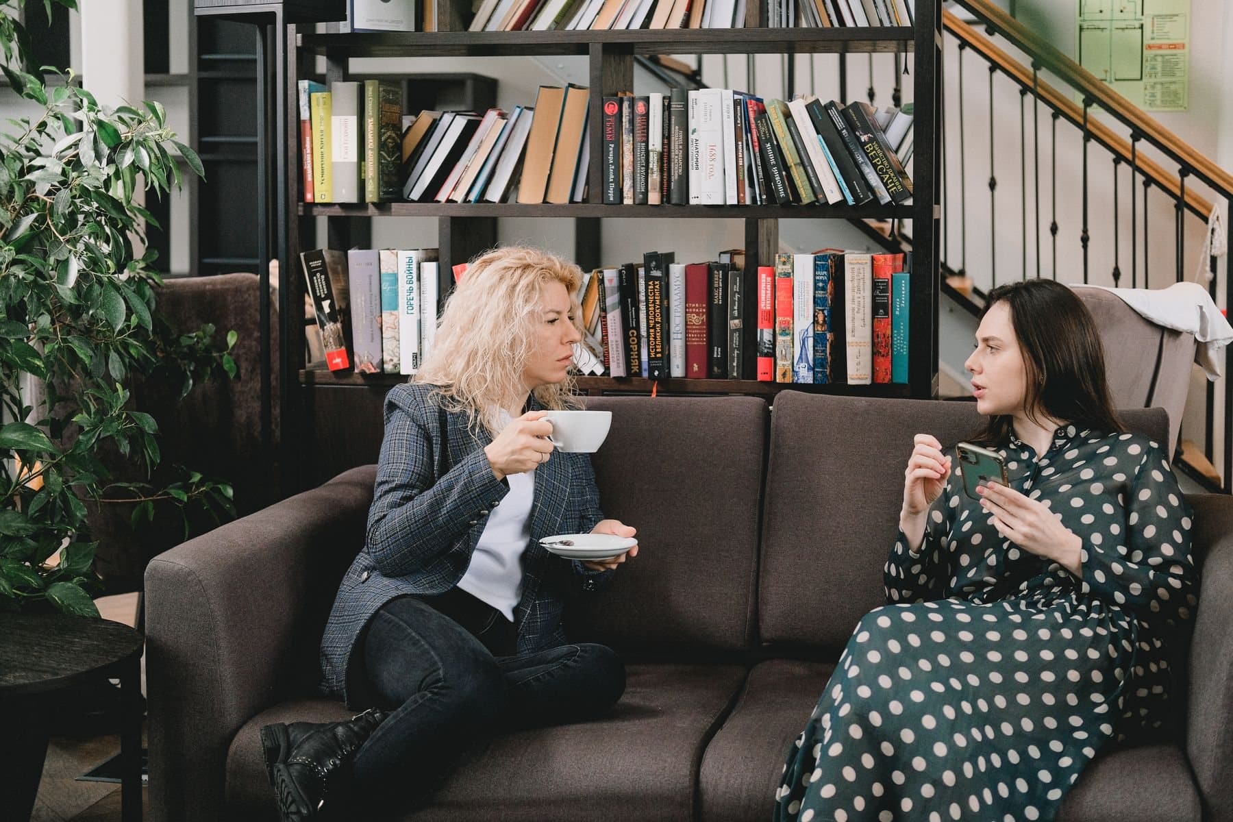Two colleagues talking over coffee on a sofa