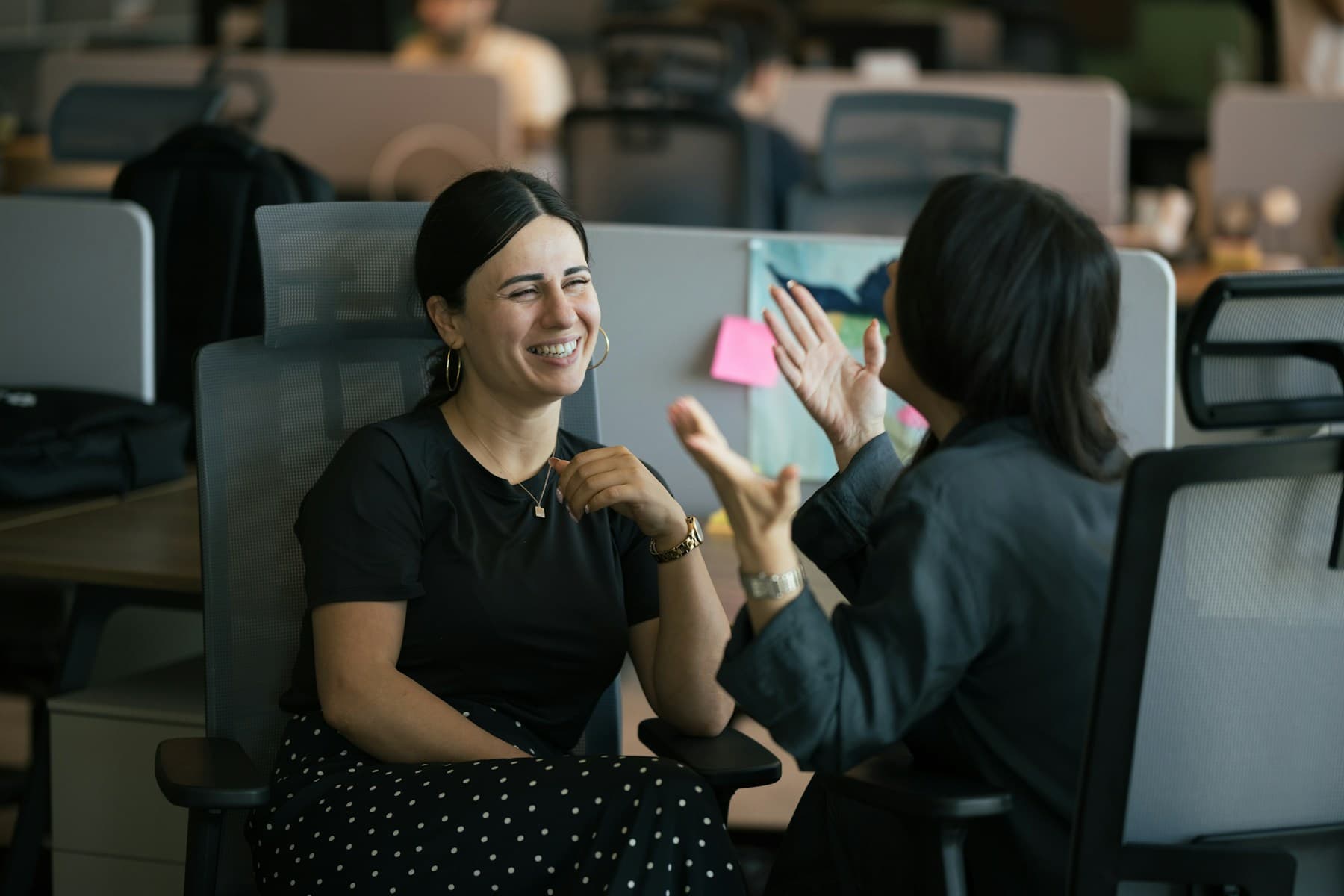 Two colleagues working at adjacent desks in an open office