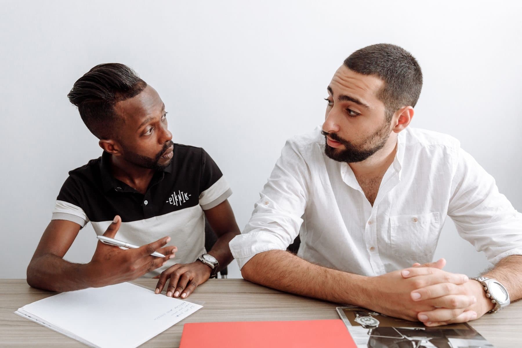 Two colleagues reviewing documents across a table